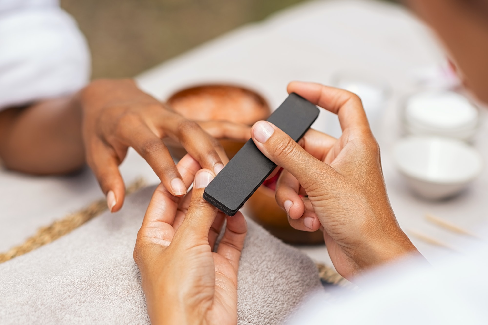 woman using a buffer to file nail